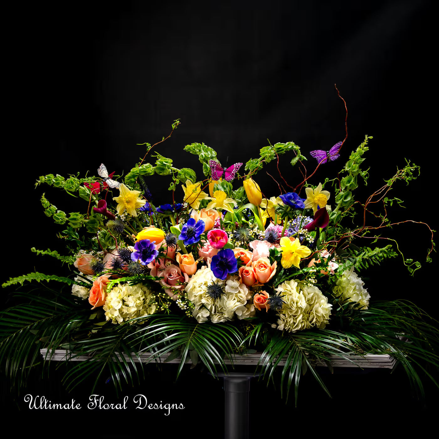 Large garden-style arrangement with roses, daffodils, hydrangeas, iris, tulips, and butterflies — Ultimate Floral Designs, Great Falls, VA