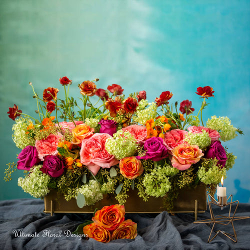 Colorful floral arrangement, consist of ranunculus, garden roses, viburnum featuring 'Ultimate Floral Designs'.